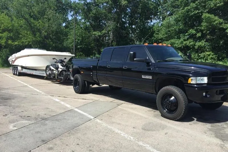 Grabbn Air Yacht Photos Pics Black truck towing 1997 Fountain 42 Lightning boat and motorcycle in parking lot.