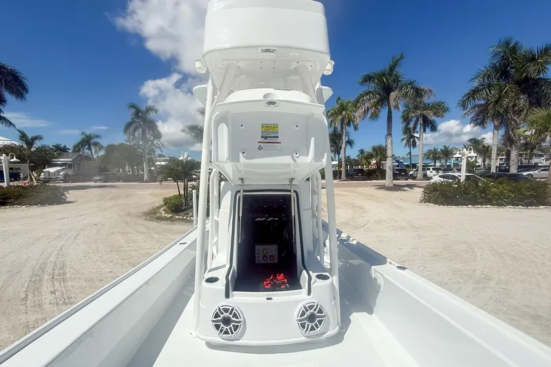  Yacht Photos Pics 2026 Yellowfin 24 Bay CE boat with tower, parked on sandy lot with palm trees.