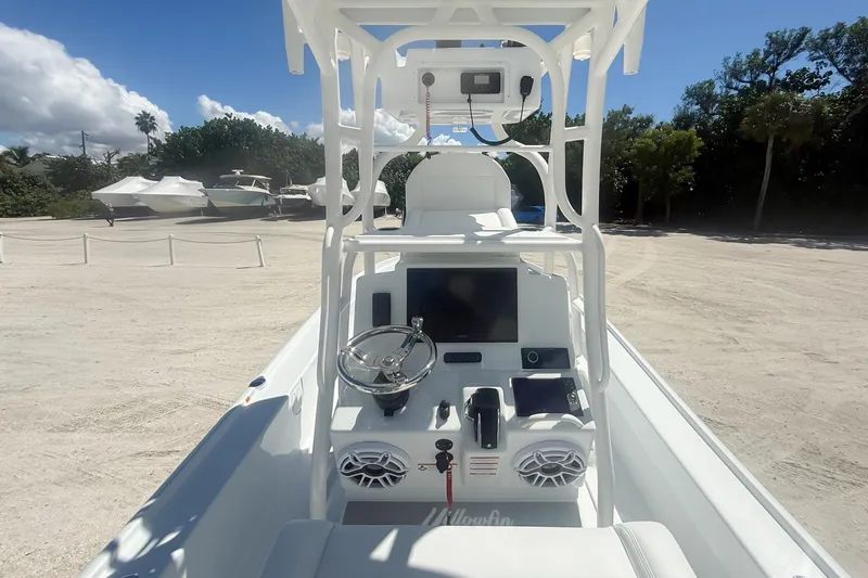  Yacht Photos Pics 2026 Yellowfin 24 Bay CE boat console with steering wheel and electronics, parked outdoors.