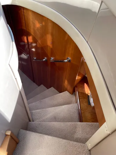 Just A Dream Yacht Photos Pics Staircase inside 2005 Carver 56 Voyager yacht with wooden paneling and carpeted steps.