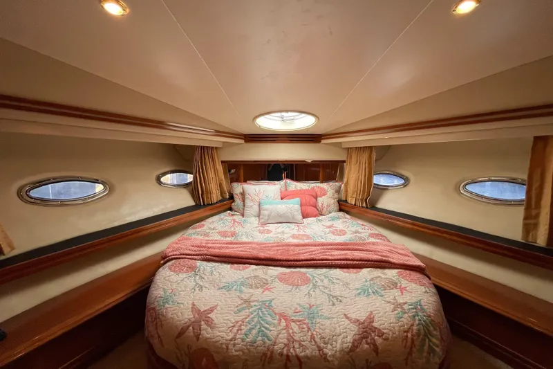 Just A Dream Yacht Photos Pics Luxurious bedroom interior of 2005 Carver 56 Voyager yacht with elegant bedding and porthole windows.