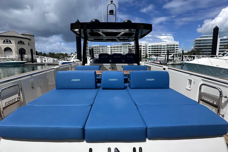 Uni Yacht Photos Pics 2020 Fjord 44 Open yacht with blue sunbeds, docked at a marina.