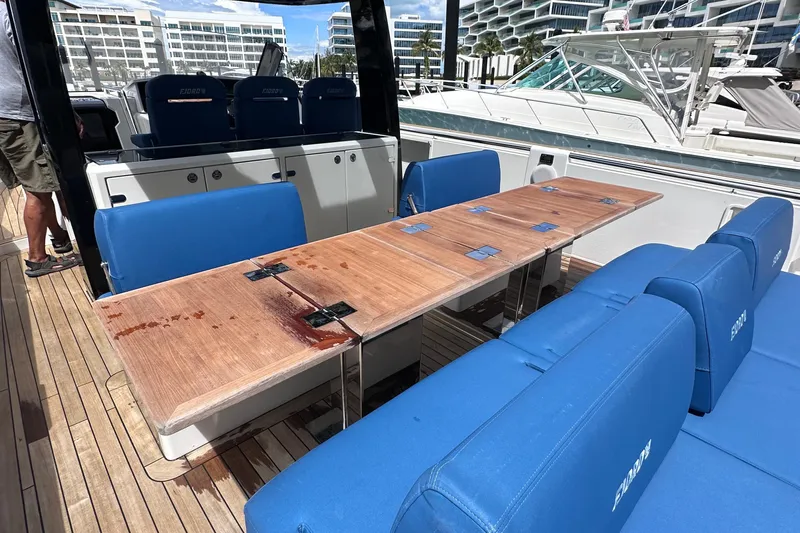 Uni Yacht Photos Pics Luxury seating area on 2020 Fjord 44 Open yacht with blue cushions and wooden table.