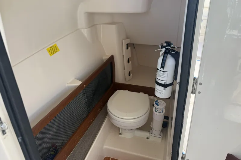275-264 Brokerage Joe Yacht Photos Pics 2022 Grady-White Freedom 275 boat interior with toilet and fire extinguisher.