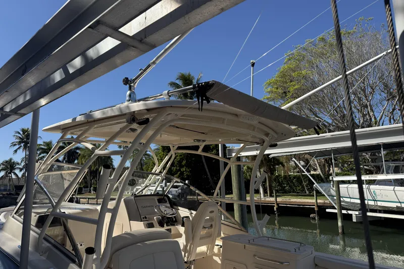 275-264 Brokerage Joe Yacht Photos Pics 2022 Grady-White Freedom 275 boat docked under a canopy, surrounded by trees.