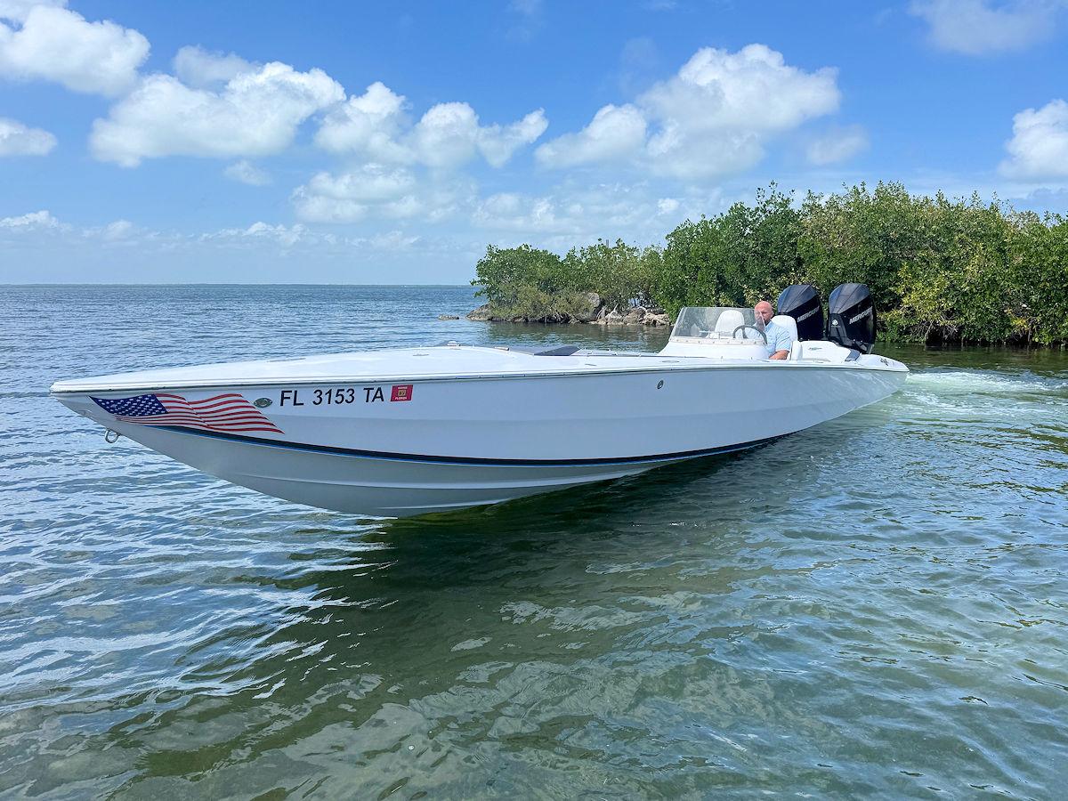 2022 Phantom 32 CC boat cruising near mangroves under a clear blue sky.