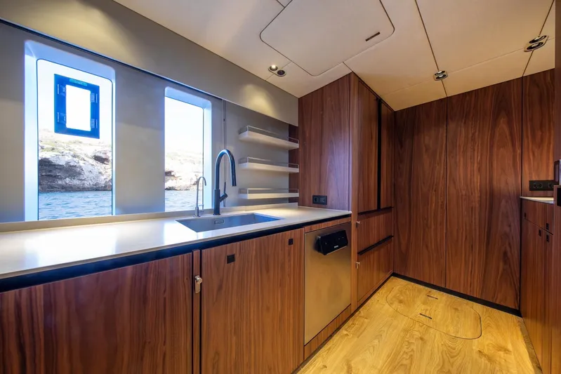 Vahewa Yacht Photos Pics Luxurious 2024 Sunreef Power Cat kitchen with sleek wood cabinetry and ocean view windows.
