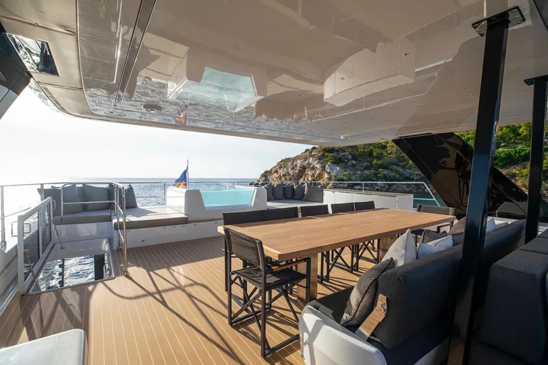 Vahewa Yacht Photos Pics Luxurious 2024 Sunreef Power Cat yacht deck with dining area and ocean view.