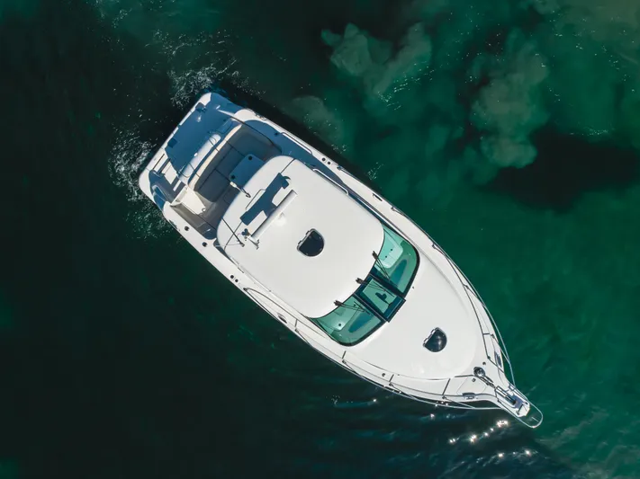 Niksen Yacht Photos Pics Aerial view of 2013 Tiara Yachts 3500 Sovran cruising in clear waters.