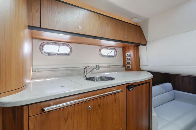 Niksen Yacht Photos Pics 2013 Tiara Yachts 3500 Sovran interior with wooden cabinetry and compact kitchenette.