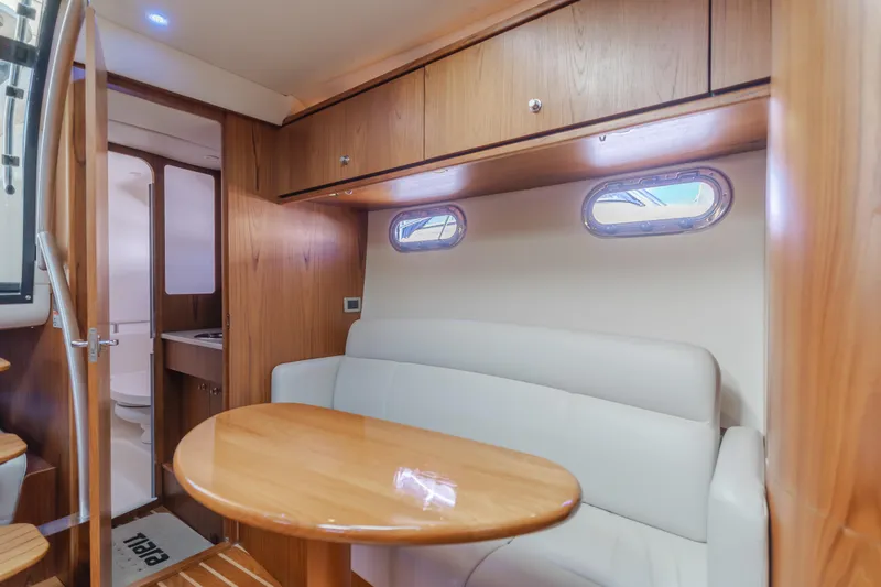 Niksen Yacht Photos Pics 2013 Tiara Yachts 3500 Sovran interior with wooden cabinetry and cozy seating area.