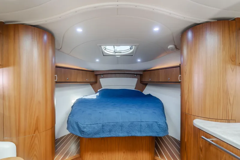 Niksen Yacht Photos Pics 2013 Tiara Yachts 3500 Sovran cabin with wood finish and blue bedding.