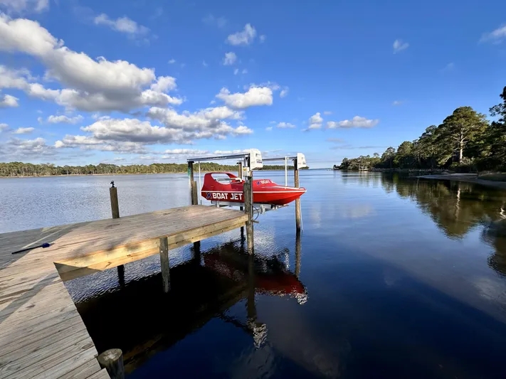 Scream Machine Yacht Photos Pics 2016 Smoky Mountain 25 Passenger Jet Boat docked on a serene lake under a blue sky.