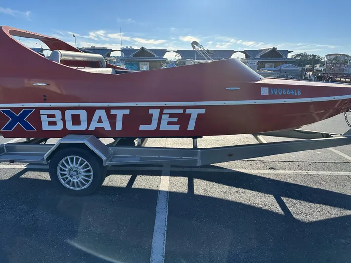 Scream Machine Yacht Photos Pics Red 2016 Smoky Mountain 25 Passenger Jet Boat on trailer in parking lot.