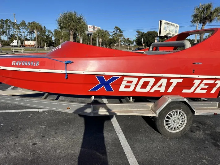 Scream Machine Yacht Photos Pics Red 2016 Smoky Mountain 25 Passenger Jet Boat on trailer, parked in sunny lot.