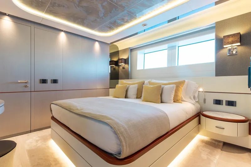 Half Irish Yacht Photos Pics Luxurious bedroom interior of 2024 Mangusta Oceano 44 yacht, featuring modern design and ambient lighting.