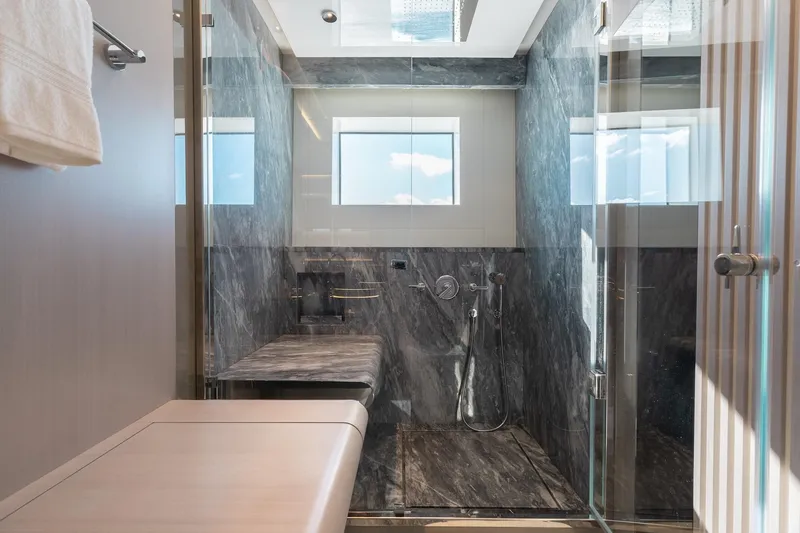 Half Irish Yacht Photos Pics Luxurious bathroom in 2024 Mangusta Oceano 44 yacht with marble shower and modern fixtures.