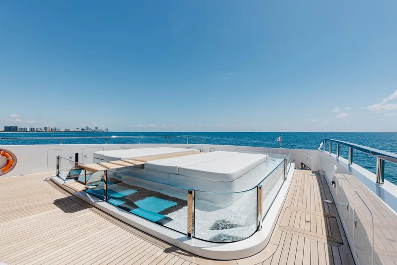 Half Irish Yacht Photos Pics Luxurious 2024 Mangusta Oceano 44 yacht deck with jacuzzi, ocean view, and city skyline.