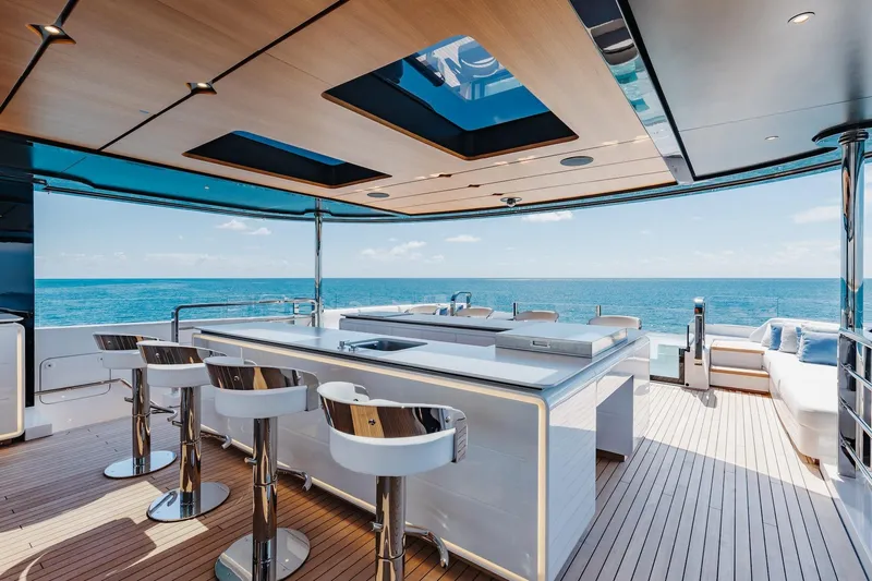 Half Irish Yacht Photos Pics Luxurious 2024 Mangusta Oceano 44 yacht deck with modern bar and ocean view.