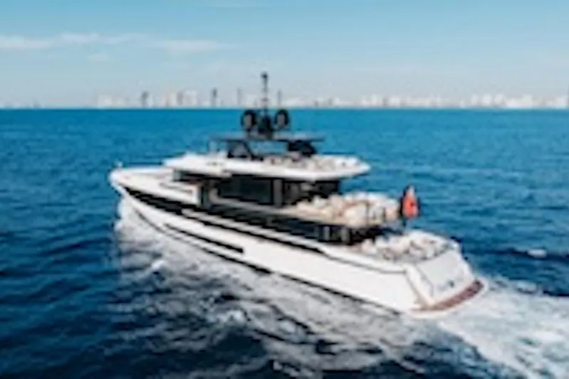 Half Irish Yacht Photos Pics 2024 Mangusta Oceano 44 yacht cruising on open sea with city skyline backdrop.