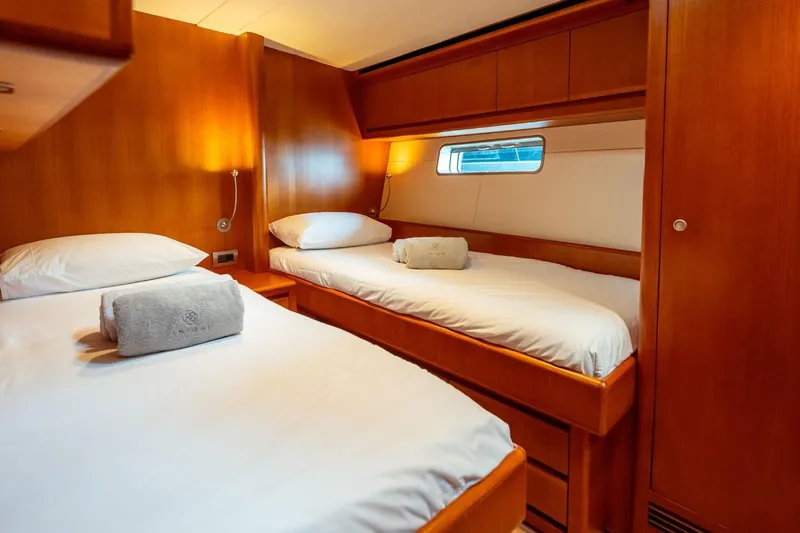 Ikigai Yacht Photos Pics Luxurious twin cabin on 2002 JFA/Vitters 82 yacht with wooden interior and cozy lighting.