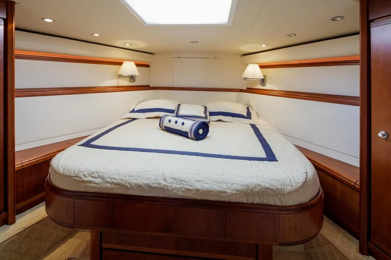  Yacht Photos Pics Luxurious bedroom interior of 2006 Bertram 570 yacht with elegant bedding and ambient lighting.