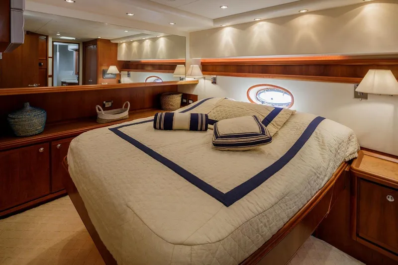  Yacht Photos Pics Luxurious bedroom interior of 2006 Bertram 570 yacht with elegant bedding and wooden accents.