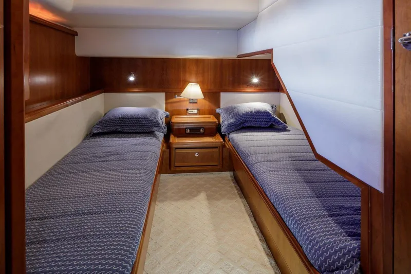  Yacht Photos Pics Twin cabin in 2006 Bertram 570 yacht with wooden interior and cozy lighting.