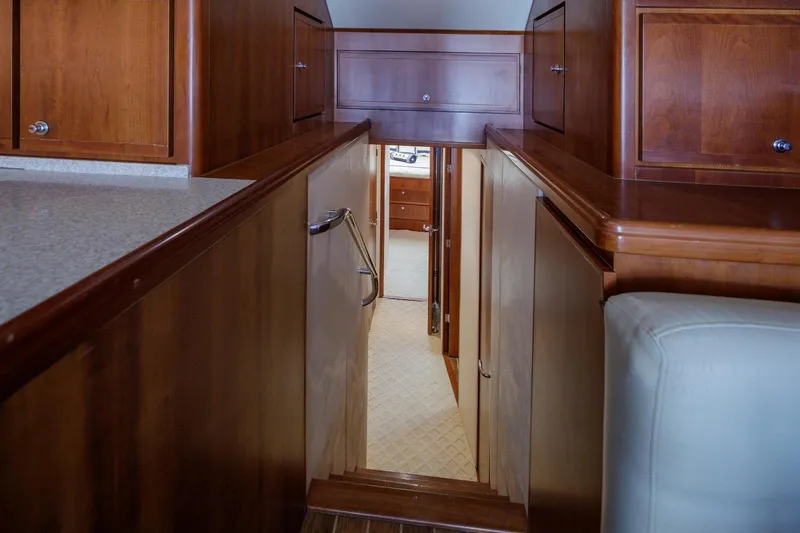  Yacht Photos Pics 2006 Bertram 570 yacht interior with wooden cabinetry and hallway view.