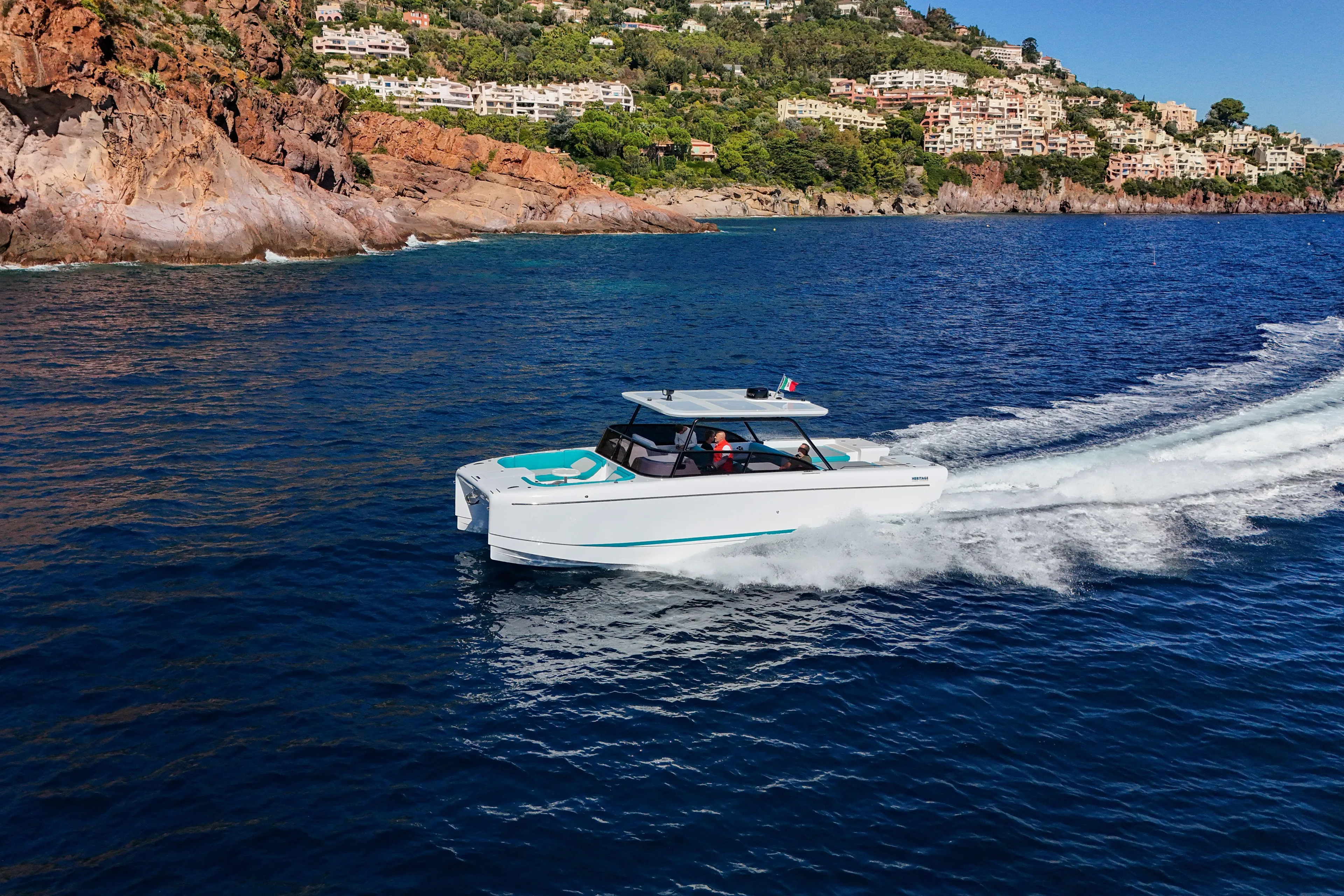  Yacht Photos Pics 2025 Canados Heritage 36 yacht cruising near rocky coastline and luxury villas.