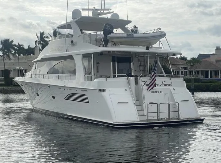 Fancier Nanci Yacht Photos Pics 2002 Cheoy Lee Sport Motor Yacht cruising in a scenic waterway, displaying an American flag.