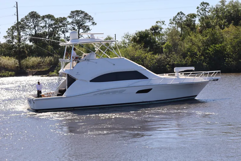  Yacht Photos Pics 2012 Bertram 511 yacht cruising on a calm river with lush greenery in the background.