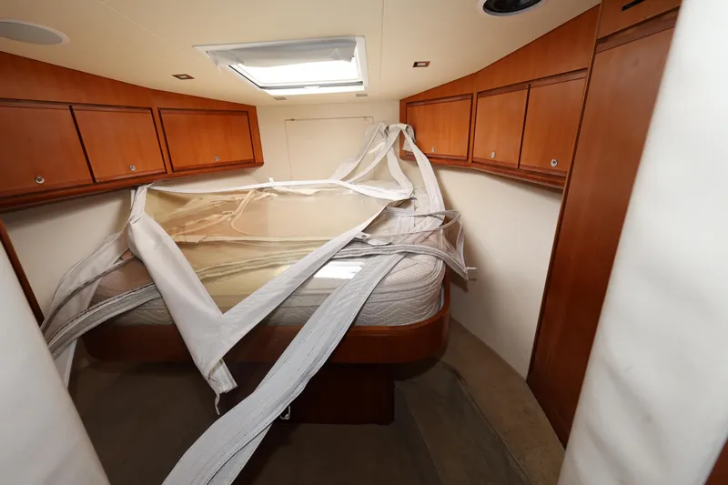 Yacht Photos Pics Interior of 2012 Bertram 511 yacht cabin with wooden cabinets and bed.