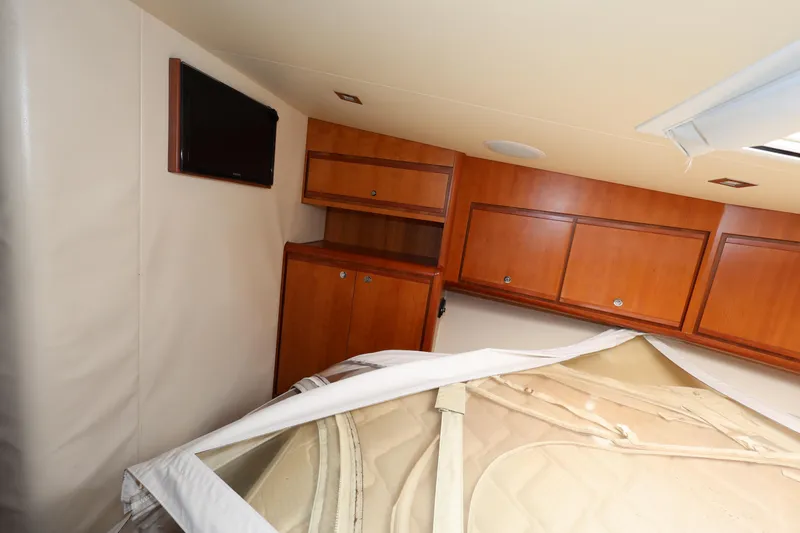  Yacht Photos Pics Interior cabin of 2012 Bertram 511 yacht with wooden cabinets and a mounted TV.
