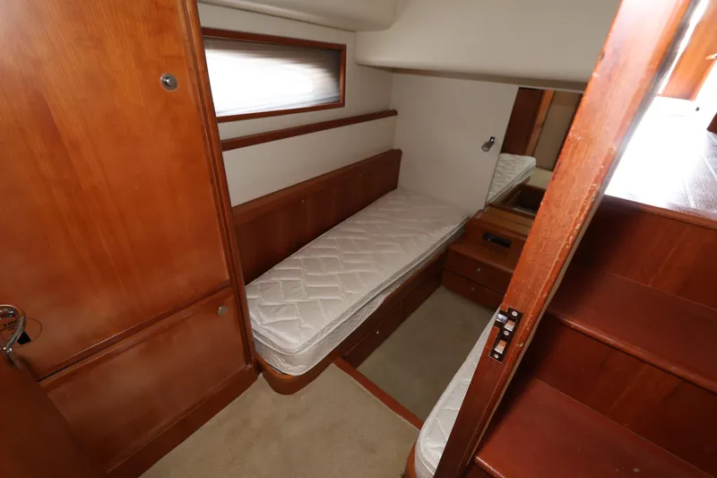  Yacht Photos Pics Cozy cabin interior of 2012 Bertram 511 yacht with wooden furnishings and single bed.