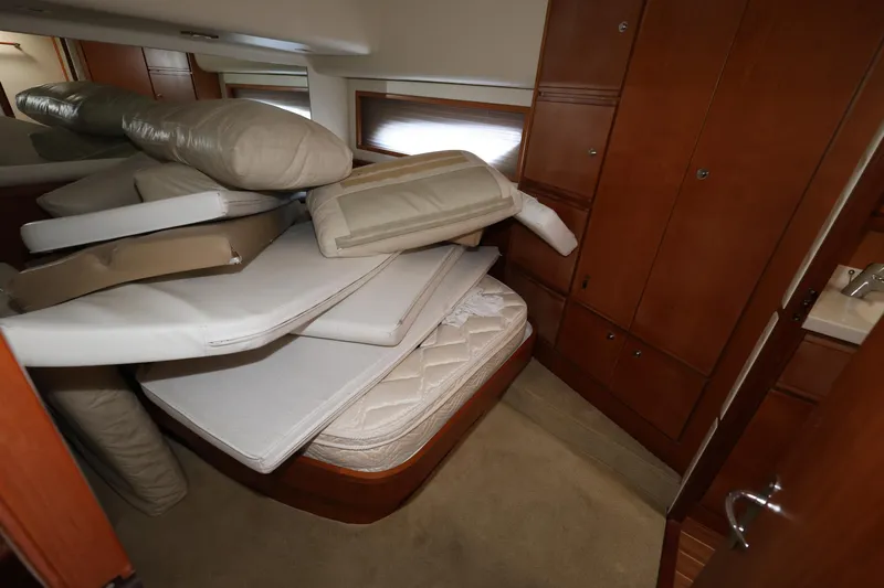  Yacht Photos Pics Cabin interior of 2012 Bertram 511 yacht with stacked mattresses and wooden cabinetry.