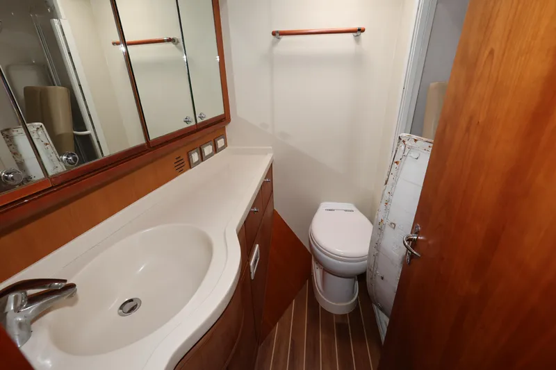  Yacht Photos Pics Bathroom interior of 2012 Bertram 511 yacht with sink, toilet, and wooden cabinetry.