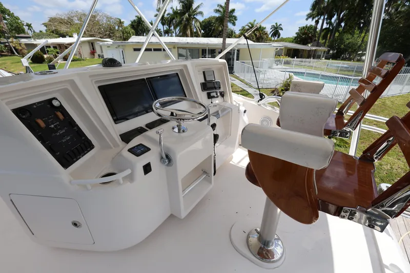  Yacht Photos Pics Bertram 511 yacht helm with dual seats, modern controls, and scenic outdoor view.