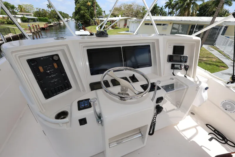  Yacht Photos Pics Control panel of a 2012 Bertram 511 yacht with steering wheel and navigation screens.