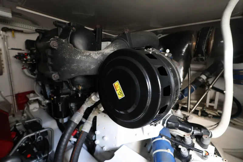  Yacht Photos Pics Engine room of a 2012 Bertram 511 yacht, showcasing mechanical components and piping.