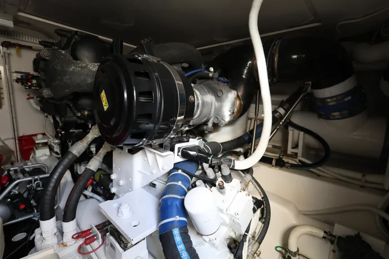  Yacht Photos Pics Engine room of a 2012 Bertram 511 yacht, showcasing complex machinery and piping.