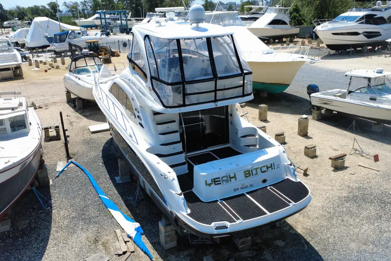  Yacht Photos Pics 2007 Sea Ray 52 Sedan Bridge yacht in a boatyard, surrounded by other vessels.