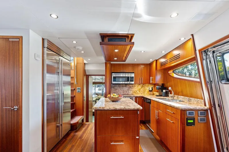 Griffin Yacht Photos Pics Luxurious kitchen interior of 2013 Hatteras 80 Motor Yacht with wood cabinetry and modern appliances.