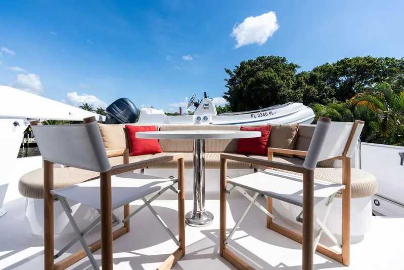 Griffin Yacht Photos Pics Outdoor seating area on 2013 Hatteras 80 Motor Yacht with table and chairs.