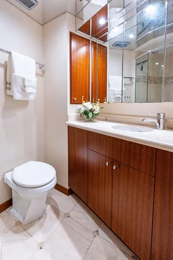 Griffin Yacht Photos Pics Luxurious bathroom in 2013 Hatteras 80 Motor Yacht with elegant wood cabinetry and modern fixtures.