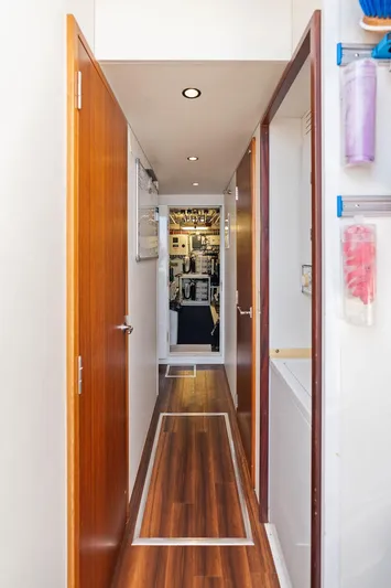 Griffin Yacht Photos Pics Hallway inside 2013 Hatteras 80 Motor Yacht with wooden flooring and open doors.