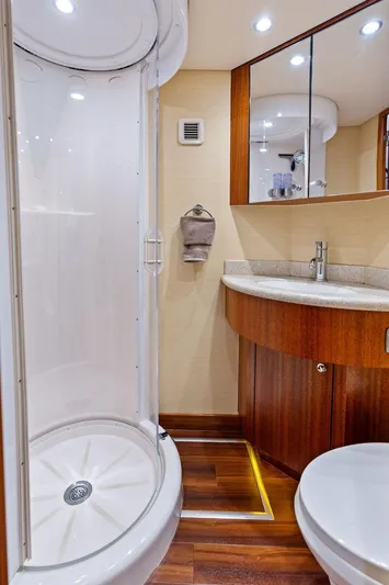 Griffin Yacht Photos Pics Luxurious bathroom in 2013 Hatteras 80 Motor Yacht with modern shower and elegant wood finishes.