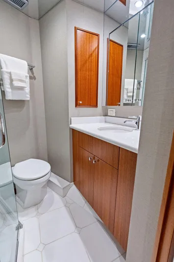Griffin Yacht Photos Pics Luxurious bathroom in 2013 Hatteras 80 Motor Yacht with modern fixtures and wood cabinetry.