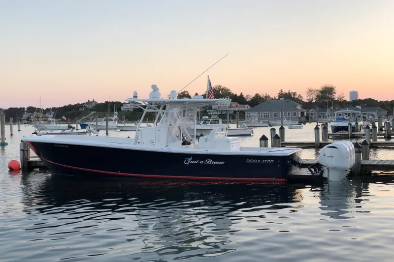 Flag Blue Yacht Photos Pics 2018 Regulator 34SS boat docked at sunset in a serene marina setting.