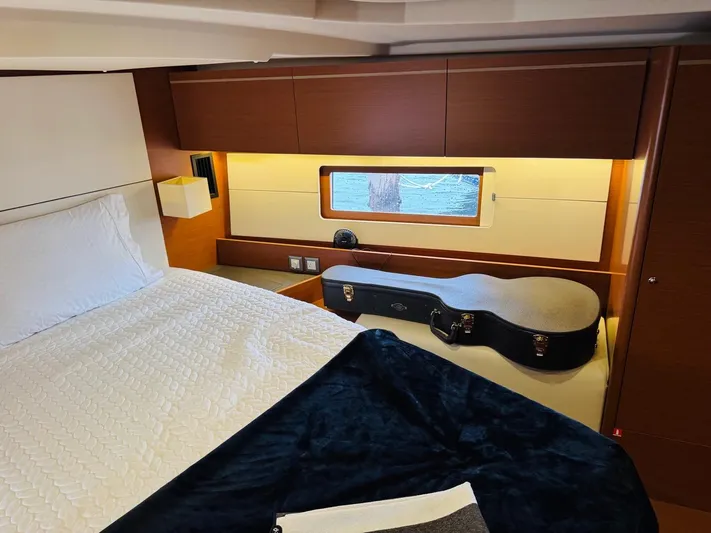 Flight Risk Yacht Photos Pics Luxurious cabin interior of 2020 Beneteau Oceanis 51.1 yacht with bed and guitar case.